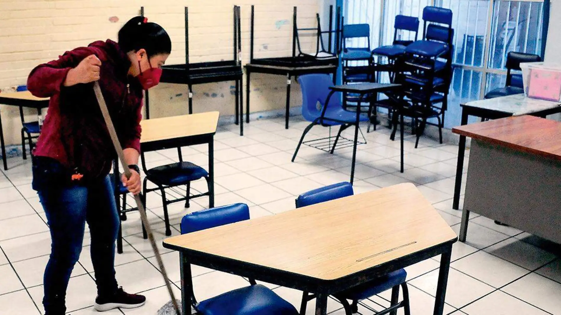 Mujer limpia salón de clases